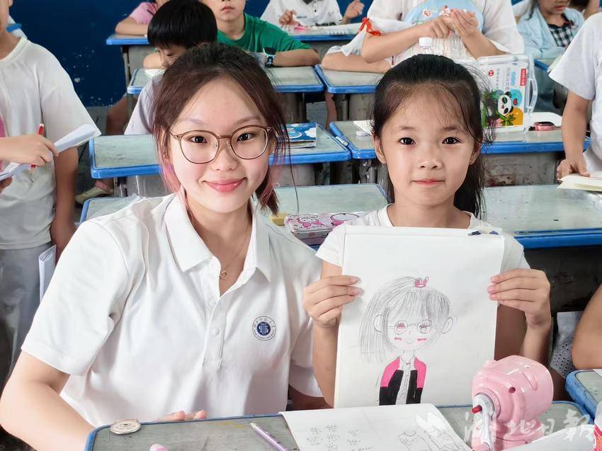 图为实践队员在美育实践课程后与手持画像的学生合影。曹悦 摄